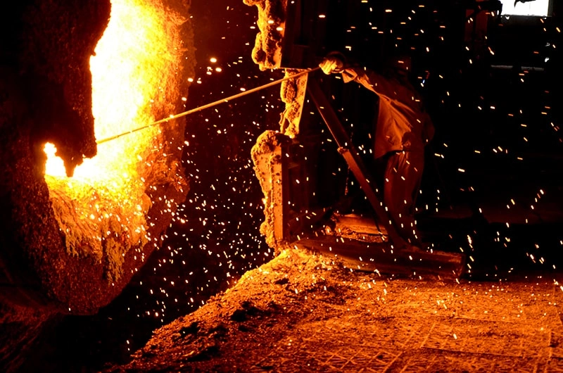 Glowing molten metal being transferred during foundry processing